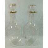 A pair of Murano clear glass decanters with gilt rims,