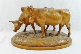 A Swiss Brienz carving of two horned cows, one with a bell,