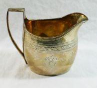 A George III silver cream jug, London 1801 by Robert and David Hennell, with reeded handle and rim,
