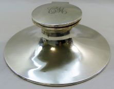 A large silver capstan inkwell, initialed 'CW' to the lid, with glass well and loaded base,