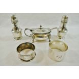 A silver three piece cruet set comprised of a mustard pot with spoon and two pepperettes,