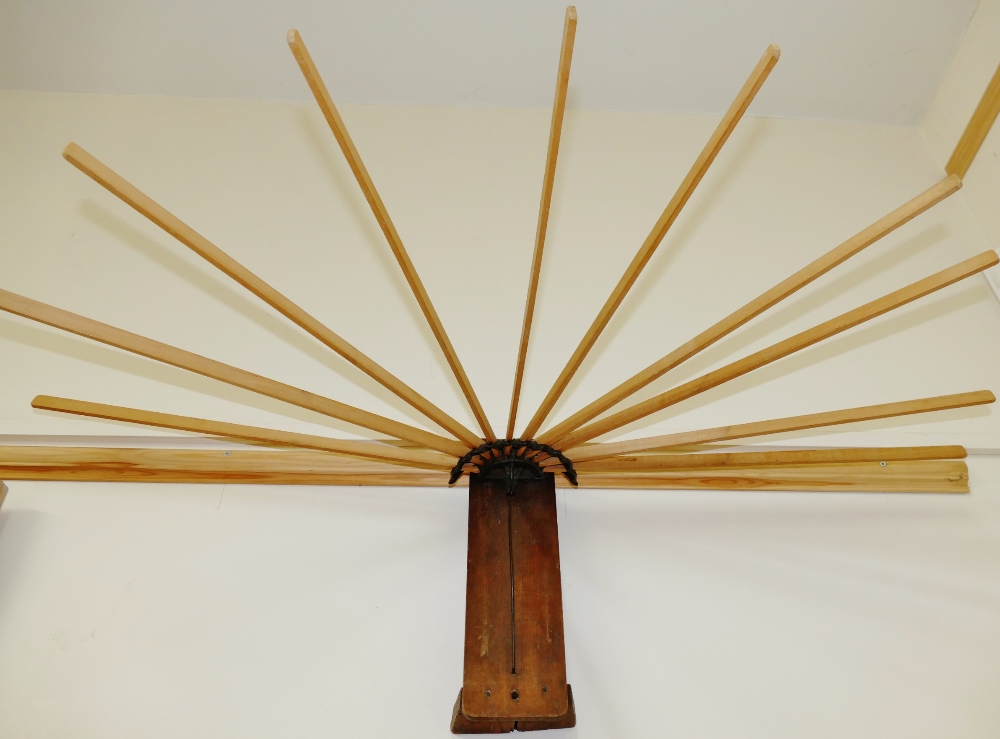 An early 20th century wall mounted folding airer, the 10 sticks each 54cm long,