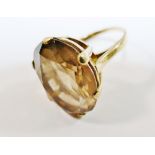 A 9 carat gold smokey quartz single stone ring, the oval mixed cut stone in claw setting,