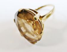 A 9 carat gold smokey quartz single stone ring, the oval mixed cut stone in claw setting,