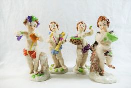 Four Naples porcelain figures of putti, depicted with a sheath of corn, a basket of flowers, wine,