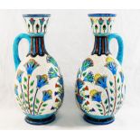A pair of French Lonwy Pottery ewers, with stylised floral enamel decoration,