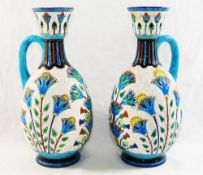 A pair of French Lonwy Pottery ewers, with stylised floral enamel decoration,