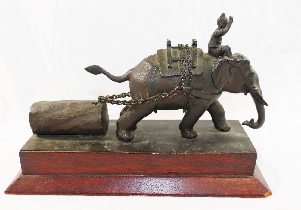 A 20th century bronze group depicting an Indian elephant and his driver pulling a log,