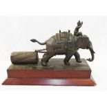 A 20th century bronze group depicting an Indian elephant and his driver pulling a log,