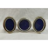 A pair of small Italian oval photograph frames and a circular similar photograph frame,