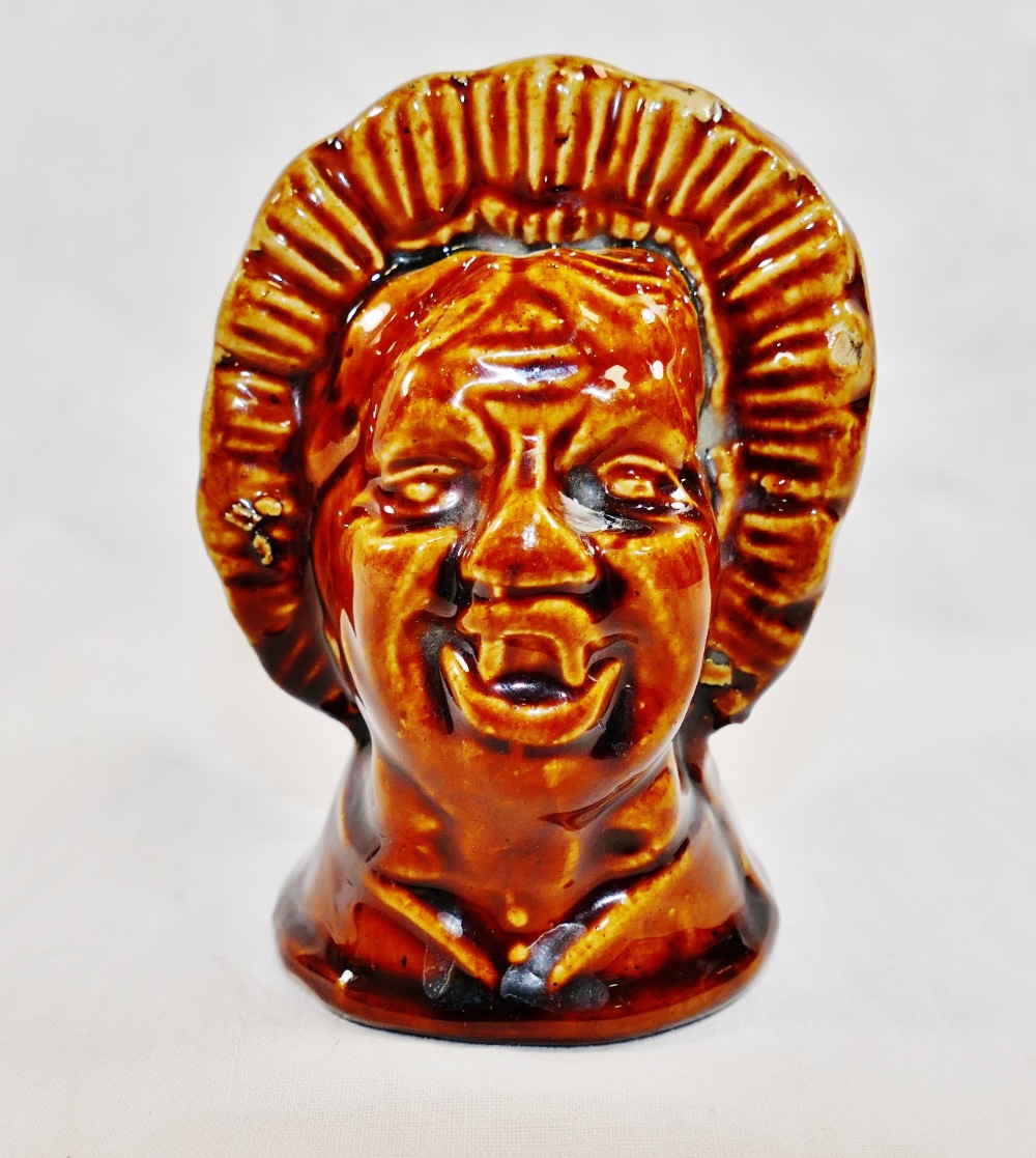 A 19th century treacle glazed stoneware money box in the form of a grotesque woman's head,