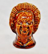 A 19th century treacle glazed stoneware money box in the form of a grotesque woman's head,