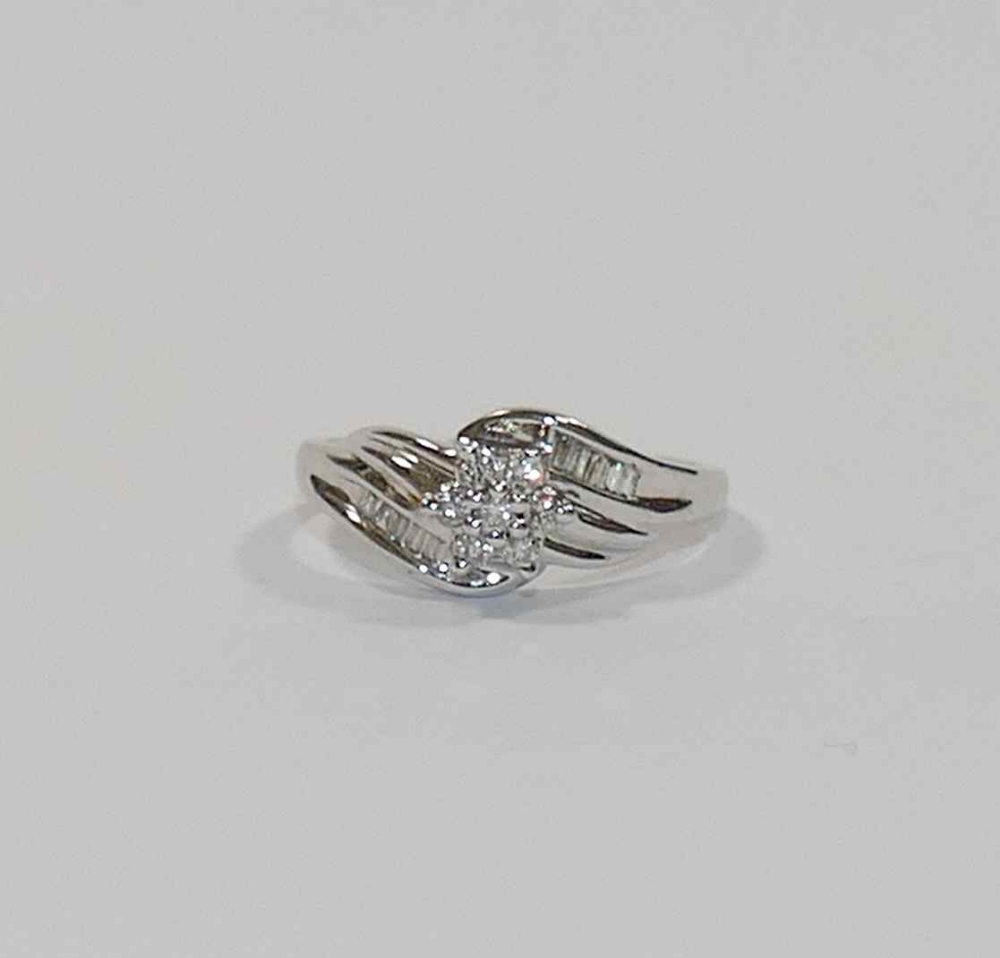 A diamond set daisy cluster cross over ring, combined weight approximately 0.