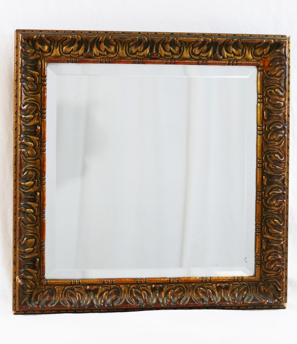 A small square bevelled edge wall mirror housed in an acanthus leaf moulded and frame with beaded