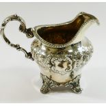 A Victorian silver cream jug, London 1849, with embossed decoration,