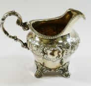 A Victorian silver cream jug, London 1849, with embossed decoration,