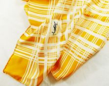 An Yves Saint Laurent yellow and white silk scarf with crossed thread pattern and YSL monogram to