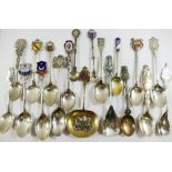 A collection of 23 sterling silver and other silver coloured metal souvenir spoons from across the
