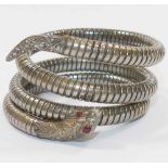 An early 20th century flexible sprung snake bracelet with red stone set eyes,