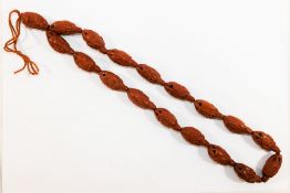 A string of 18 Chinese carved coquilla nut beads, each bead approximately 3.