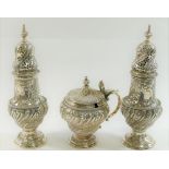 An Edwardian three piece cruet comprised of two pepperettes and a mustard,