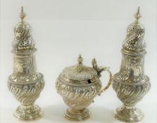 An Edwardian three piece cruet comprised of two pepperettes and a mustard,