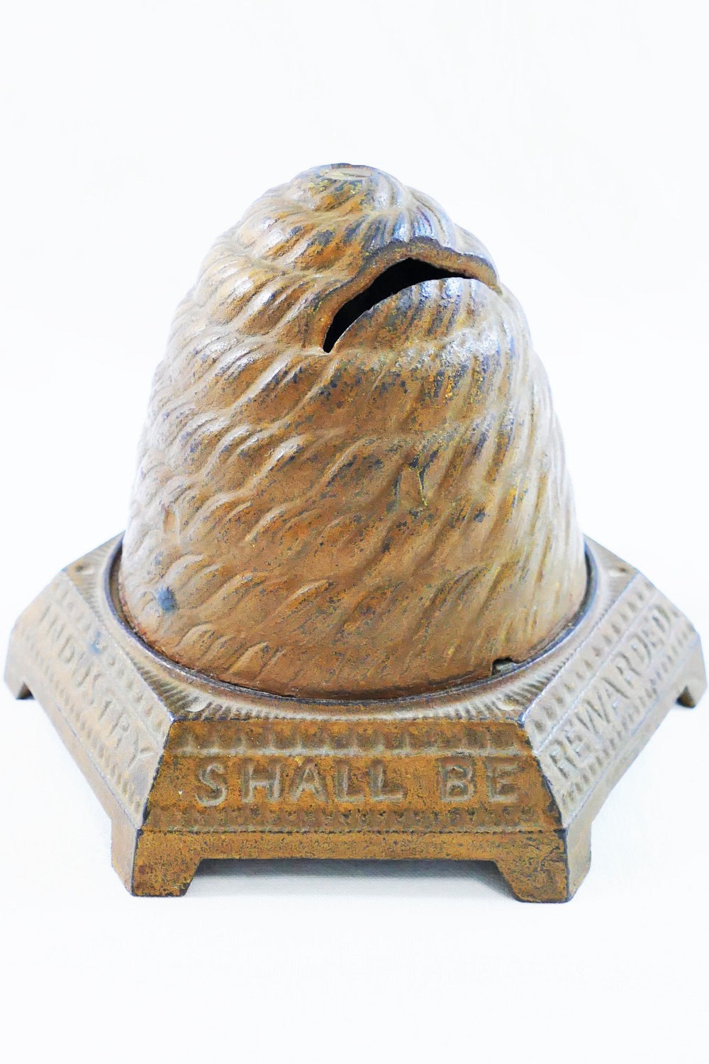 A 19th century cast iron money box in the shape of a skep beehive,