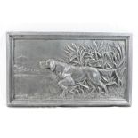 A patinated cast metal rectangular plaque depicting a gun dog amongst bull rushes,