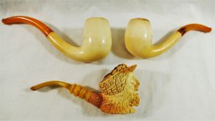 A Meerschaum pipe, the bowl carved with the head of a bearded man, laughing, wearing a hat,