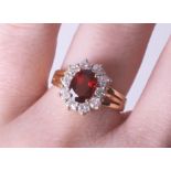 An 18ct diamond and garnet cluster ring, size M.