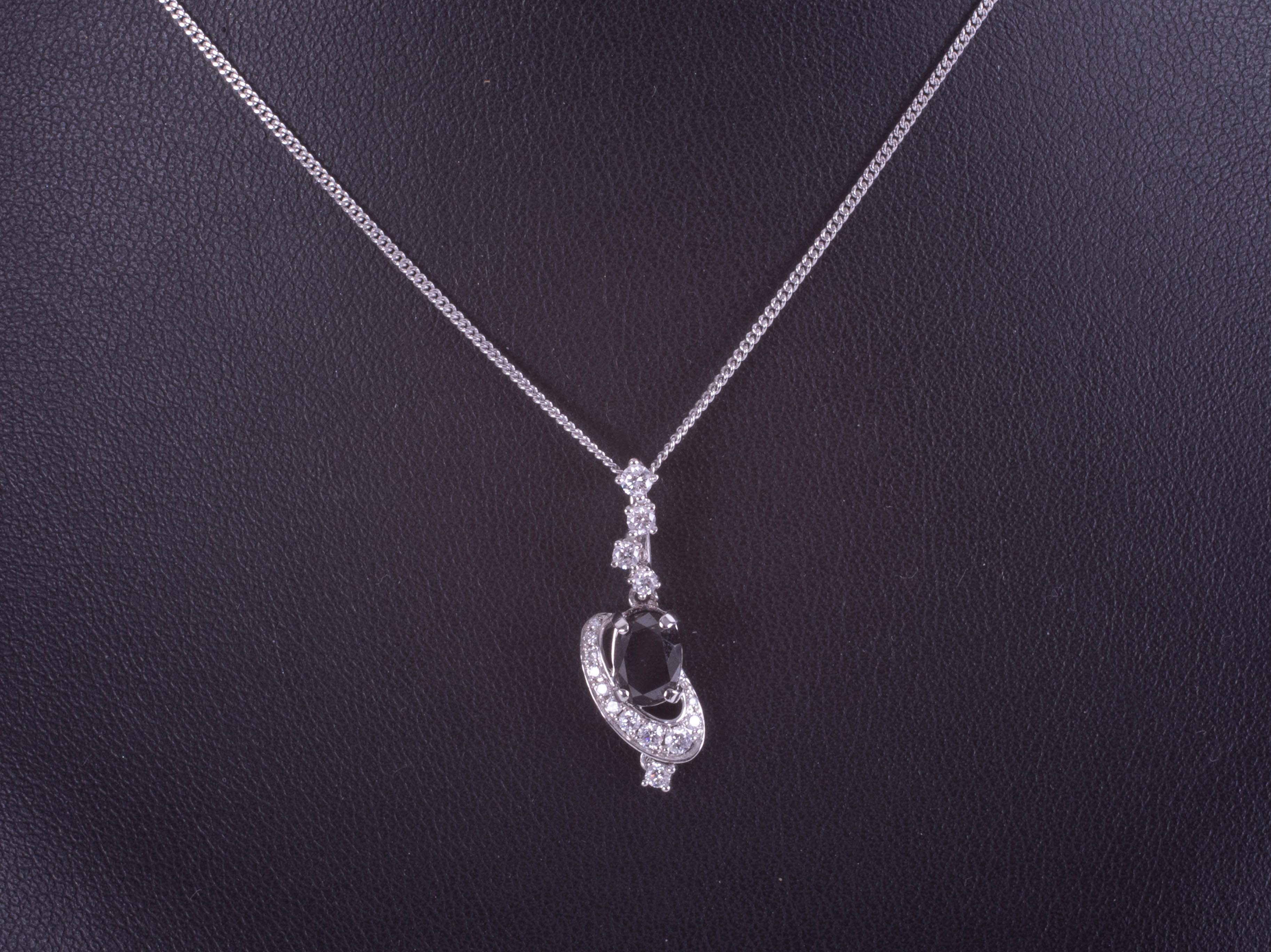 An 18ct white gold swirl pendant set with an oval black diamond and white round brilliant cut - Image 2 of 2