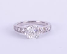 A platinum and diamond ring, set with a central round brilliant cut diamond, weighing