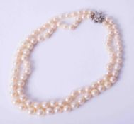 A double row pearl necklace with diamond set clasp.