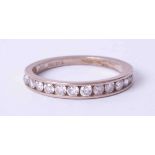 An 18ct half band channel set diamond eternity ring, size L.