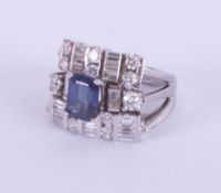 An 18ct white gold ornate dress ring set with a central rectangular sapphire and a mixture of