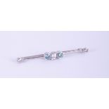 An 18ct bar brooch set with enhanced blue and white diamonds.