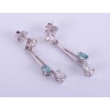 A pair contemporary 18ct white gold bar drop earrings set with enhanced blue and white diamonds.