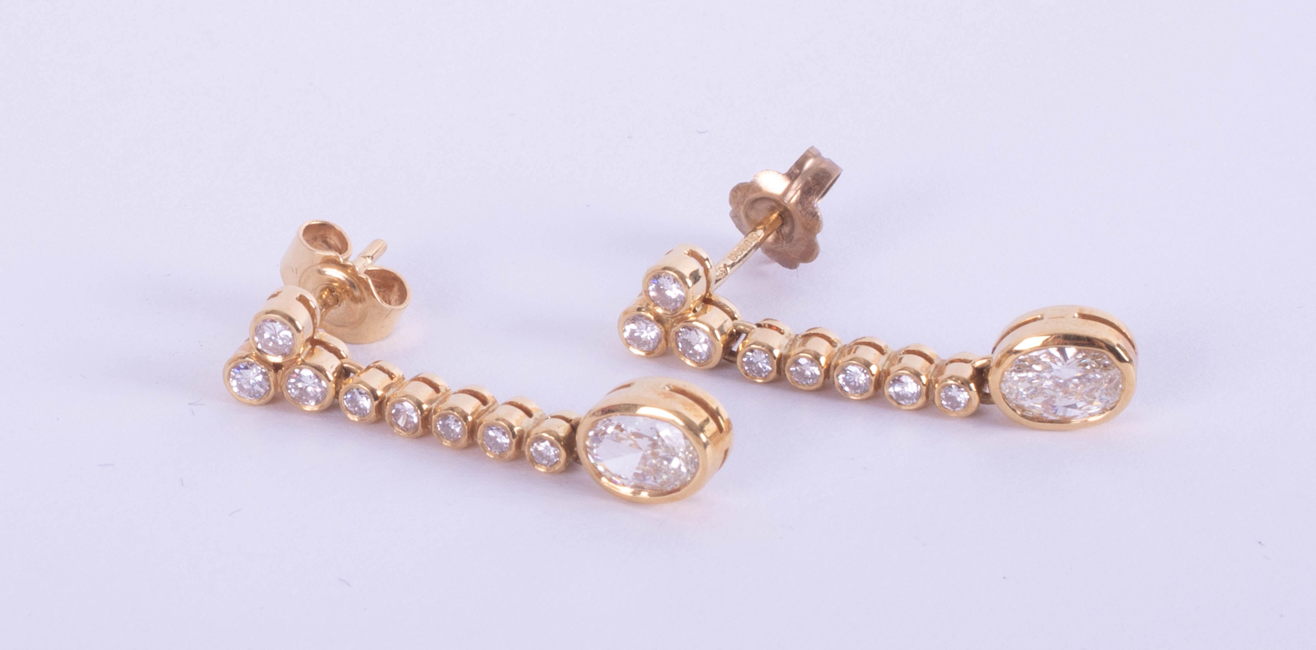 A pair 18ct yellow gold drop earrings, set with small oval brilliant cut diamonds, and further