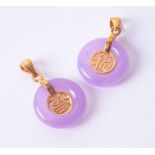 Two yellow gold plated pendants set circular lavender jade and Chinese symbols.