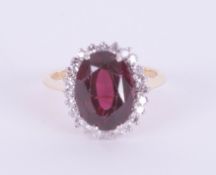 An 18ct diamond and garnet set oval cluster ring, ring size O.