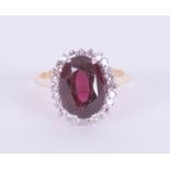 An 18ct diamond and garnet set oval cluster ring, ring size O.