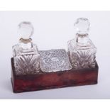 A pair of glass and silver mounted scent bottles, set in a stand, height 12cm including stopper.