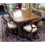 A mahogany dining table with a central insertable extension leaf with original winding handle height