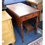 A Victorian mahogany Pembroke table on ring-turned legs fitted with a real and dummy drawers.