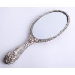 A silver hand mirror with heavy embossed scroll and ribbed decoration, mirror in good condition,