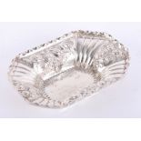 A silver rectangular dish with fluted corners and embossed scroll & foliate decoration, London maker
