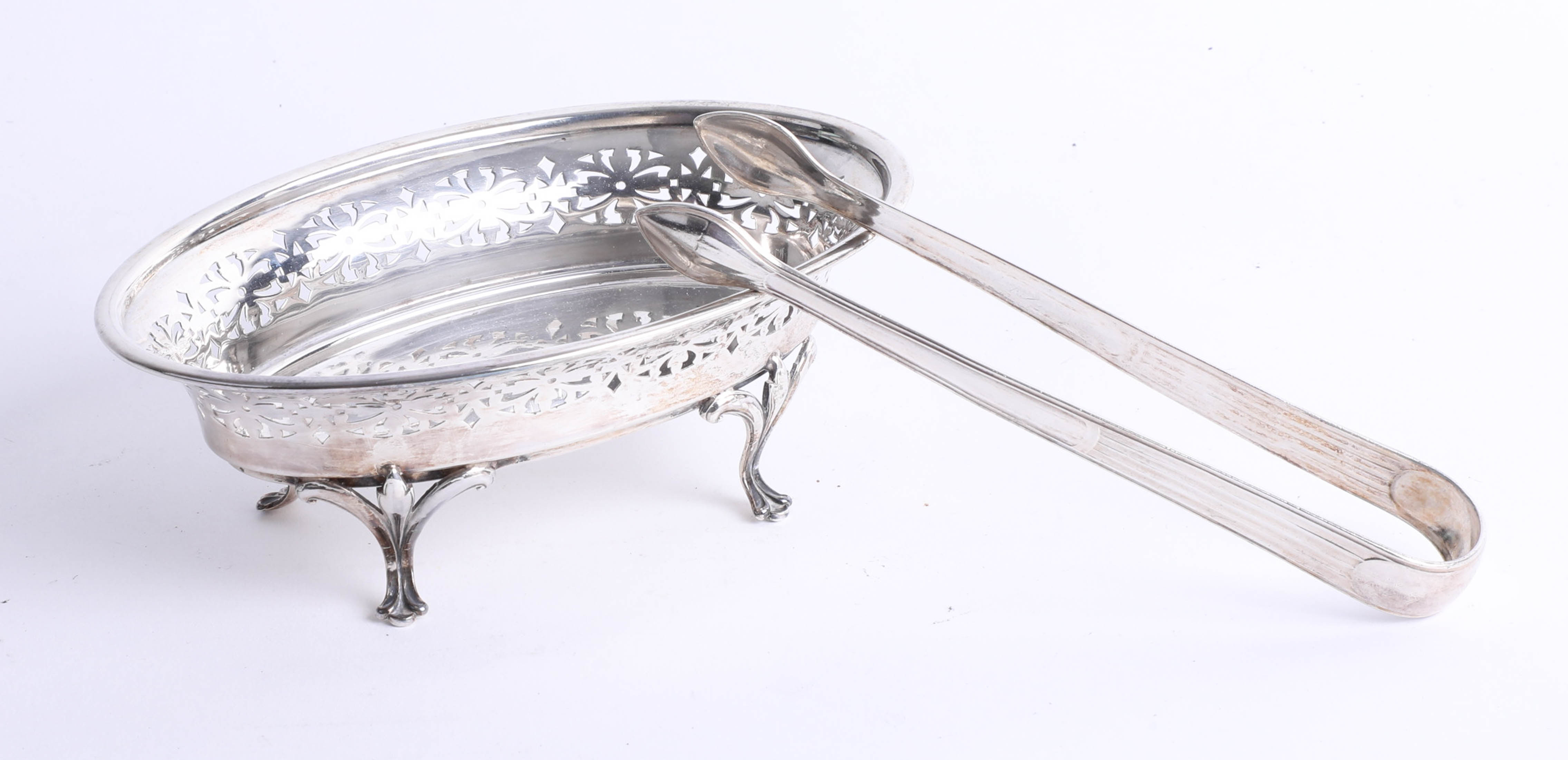 A silver sugar bowl with decorative pierced gallery on 4 Trifoil feet, Birmingham by Deakin and