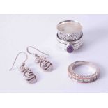 A silver and amethyst type dress ring, another silver dress ring, and a pair of silver modern