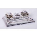 An Art Nouveau silver inkstand on bun feet.