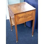 An Edwardian inlaid mahogany sewing stand with fitted interior on small brass casters.